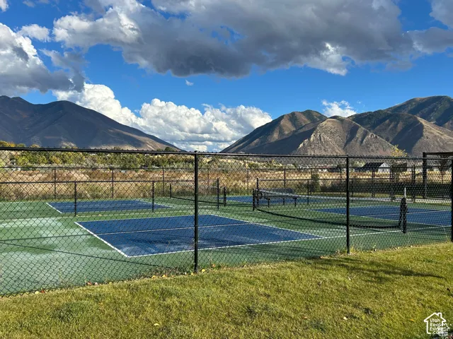 Sport court with a chain link fence, surrounded by green grass