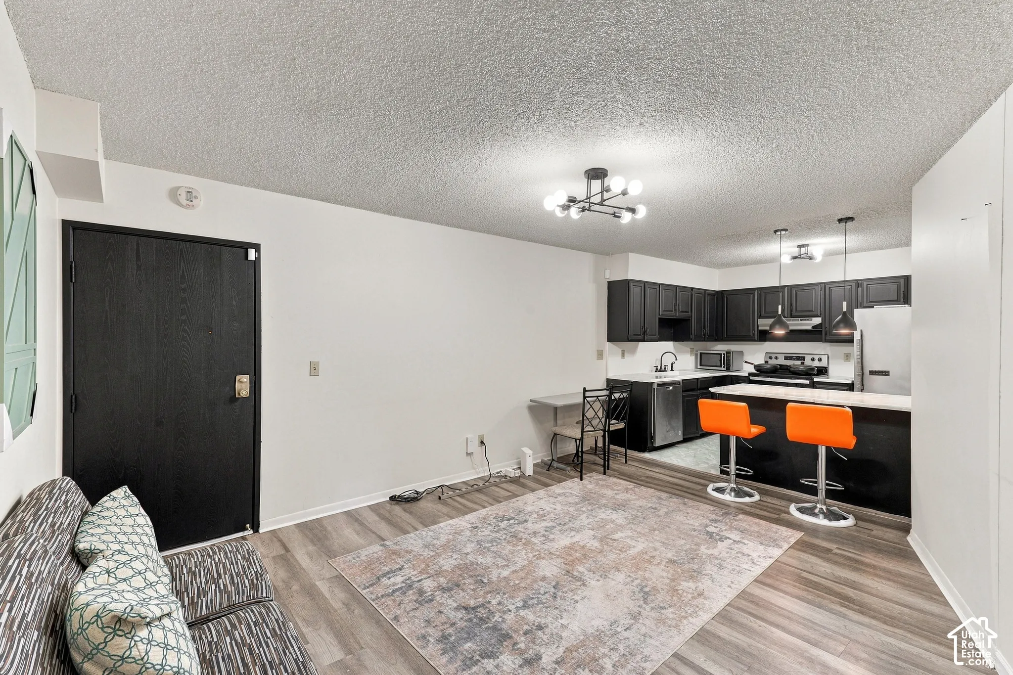 Kitchen with dark cabinetry and stainless steel appliances