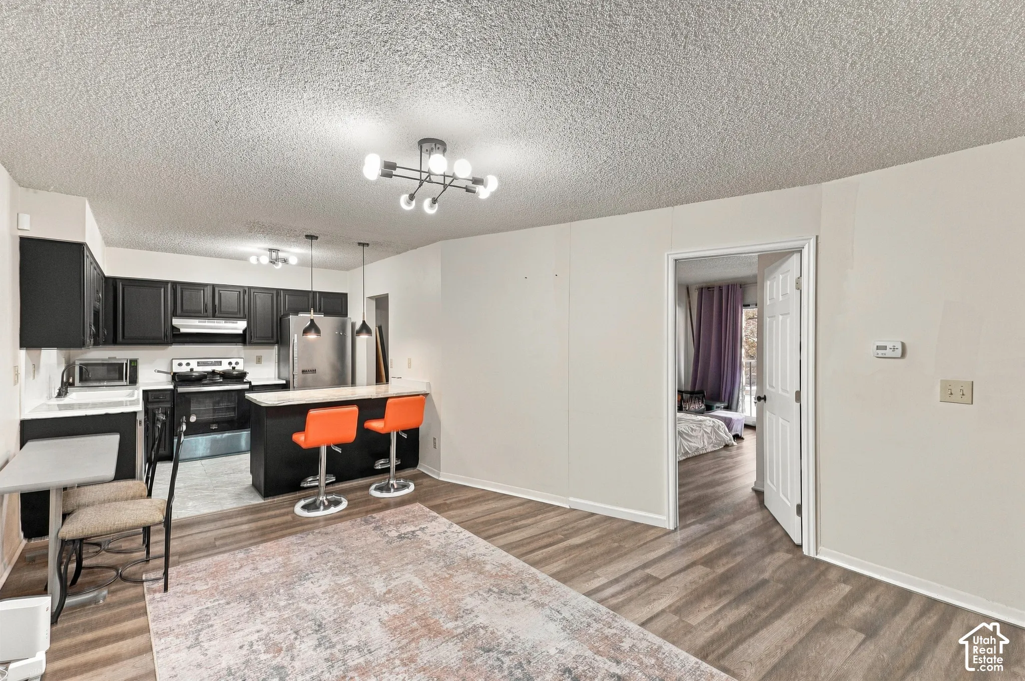 Kitchen featuring dark cabinetry, stainless steel appliances, and a breakfast bar