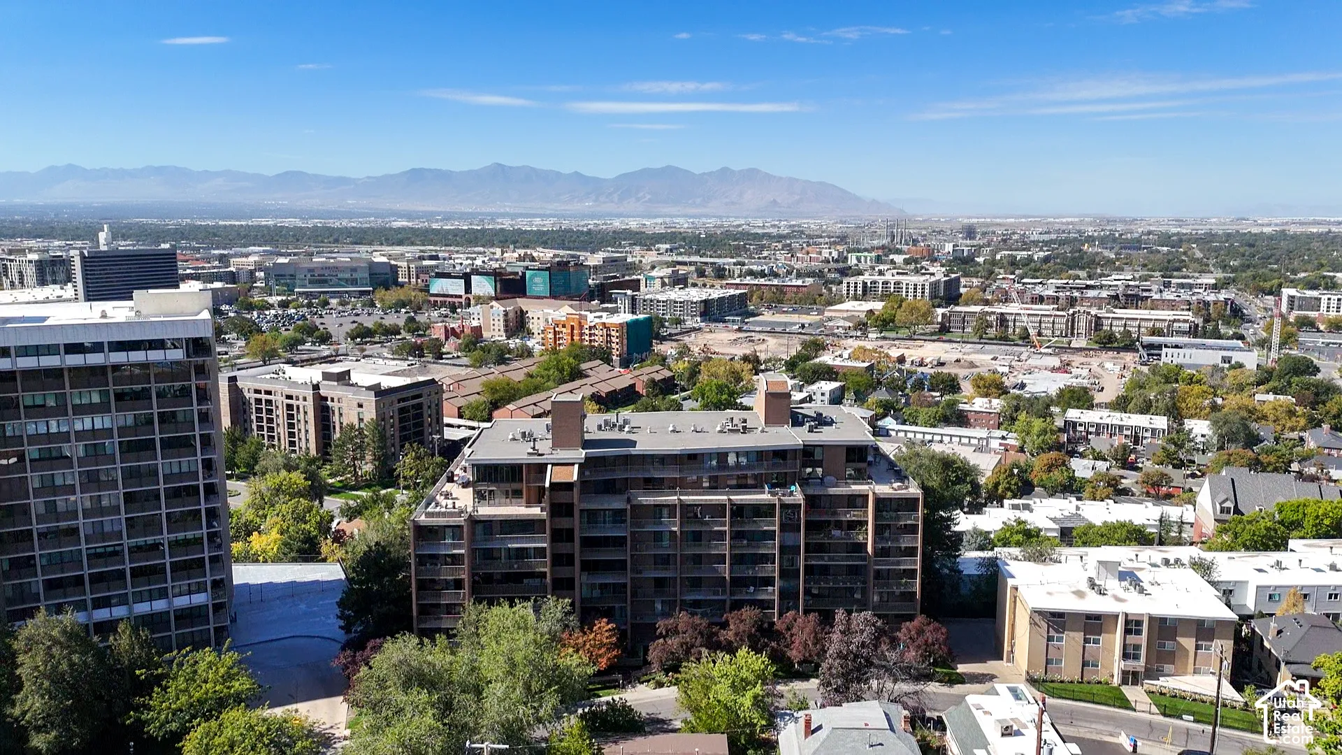 Panoramic city landscape featuring distant mountains and a clear sky