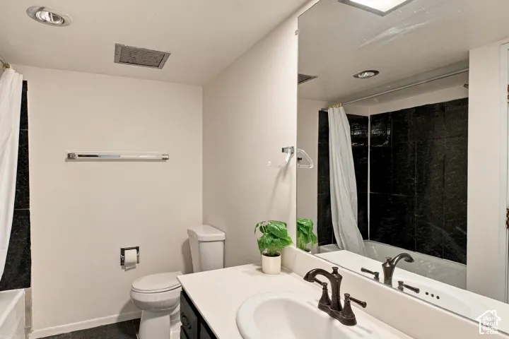 Bathroom featuring a white vanity with an integrated sink, dark bronze-finish faucet, and a large wall-mounted mirror