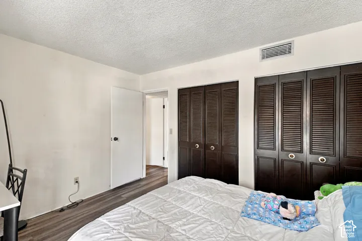 Wood-finish flooring with white walls and a textured ceiling