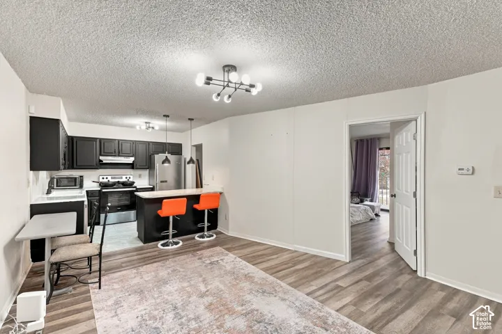 Kitchen with dark cabinetry, stainless steel appliances, and a breakfast bar