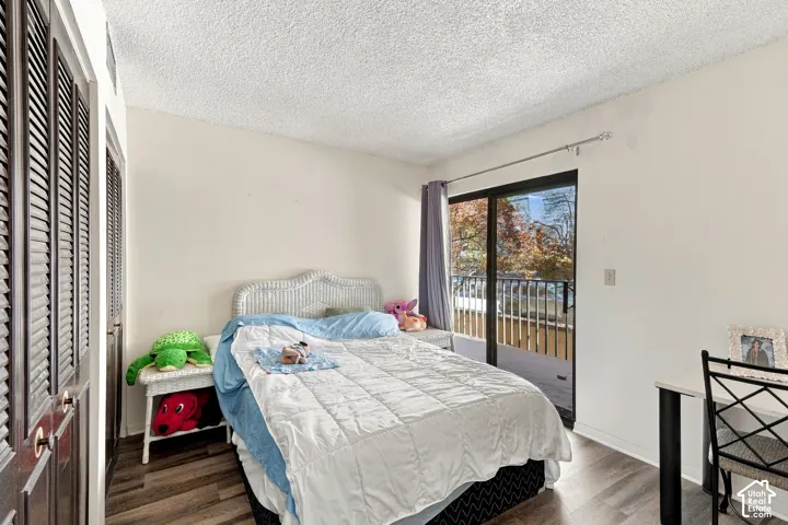 Dark wood-finish louvered closet doors, wood-finish flooring, sliding glass door, and exterior balcony