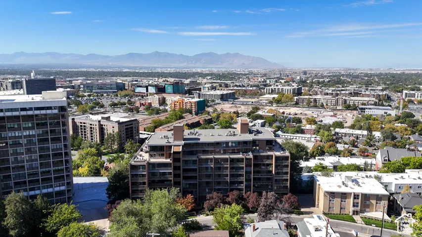 Panoramic city landscape featuring distant mountains and a clear sky