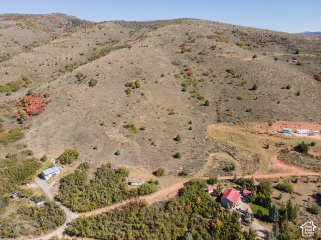 Extensive hilly terrain featuring varied natural vegetation and visible structures