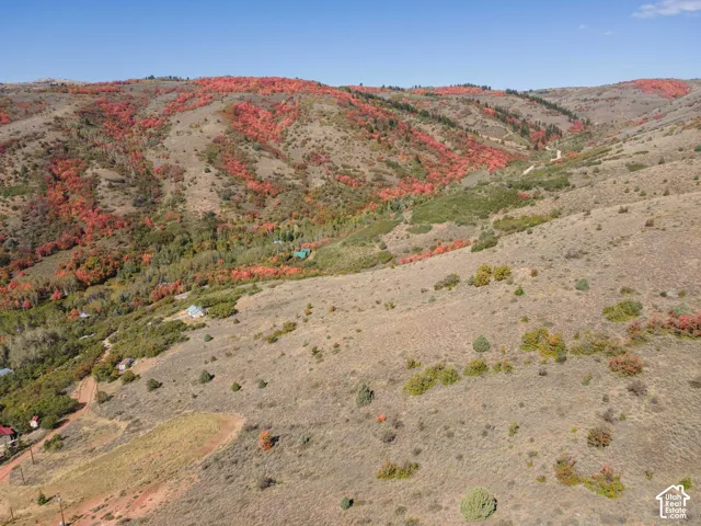 Expansive mountain terrain featuring diverse vegetation and scattered structures