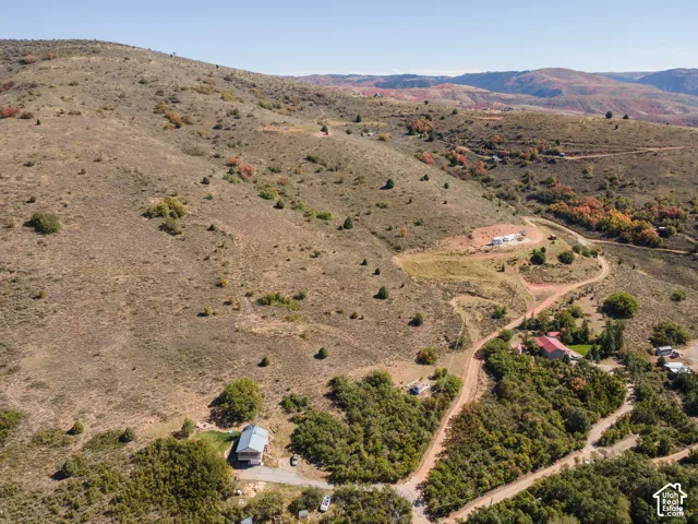 Expansive mountainous terrain with scattered greenery and visible structures