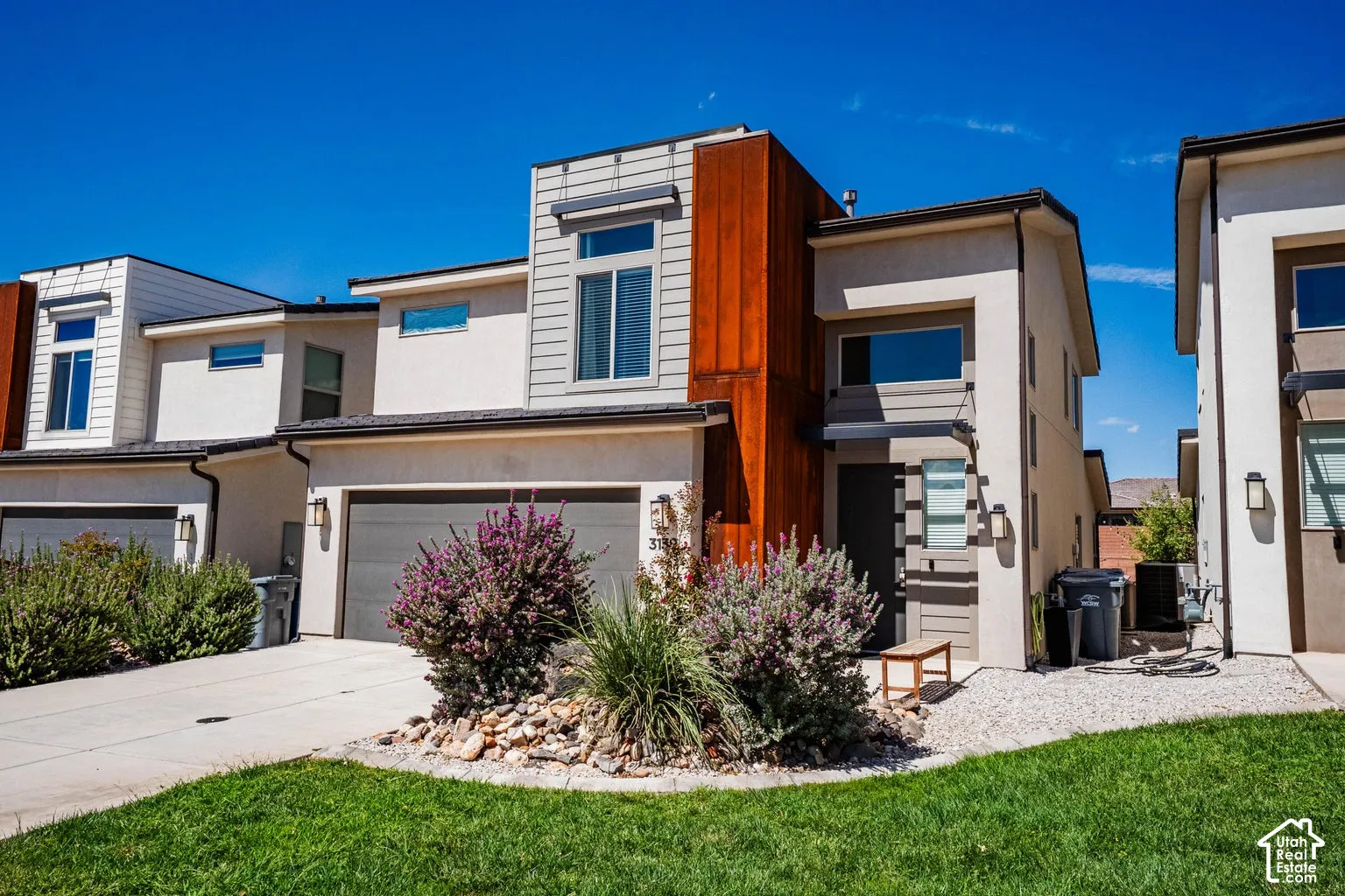 Contemporary exterior with a flat roofline, attached garage, and stucco siding