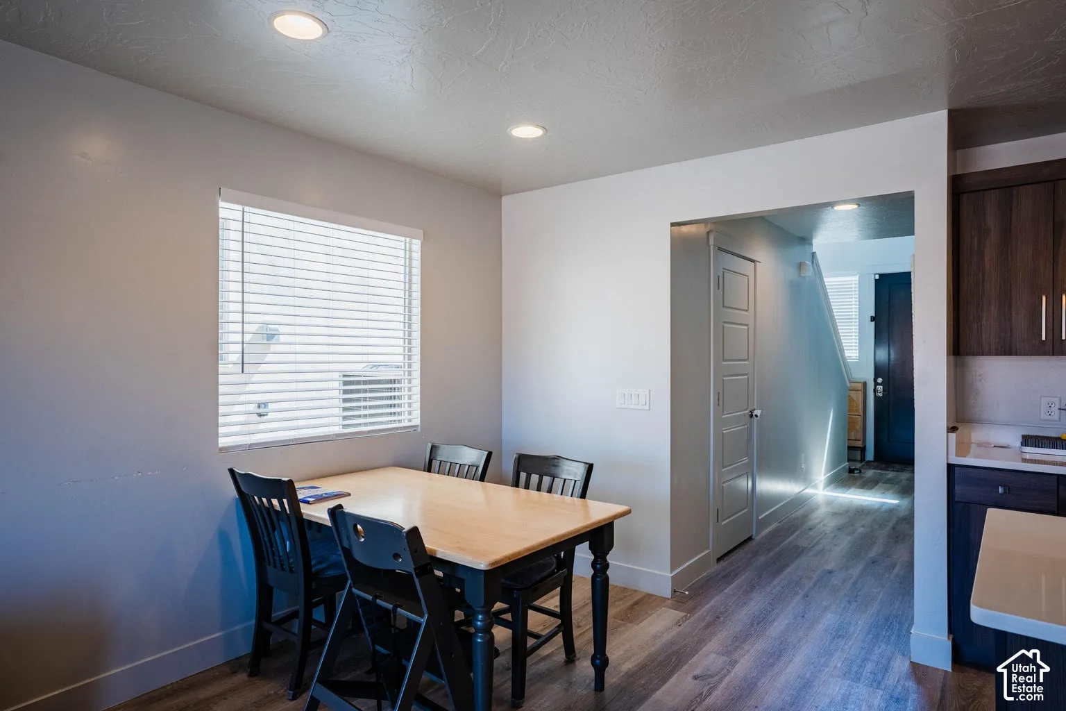 Wood-finish flooring, recessed ceiling lights, and white wall finishes