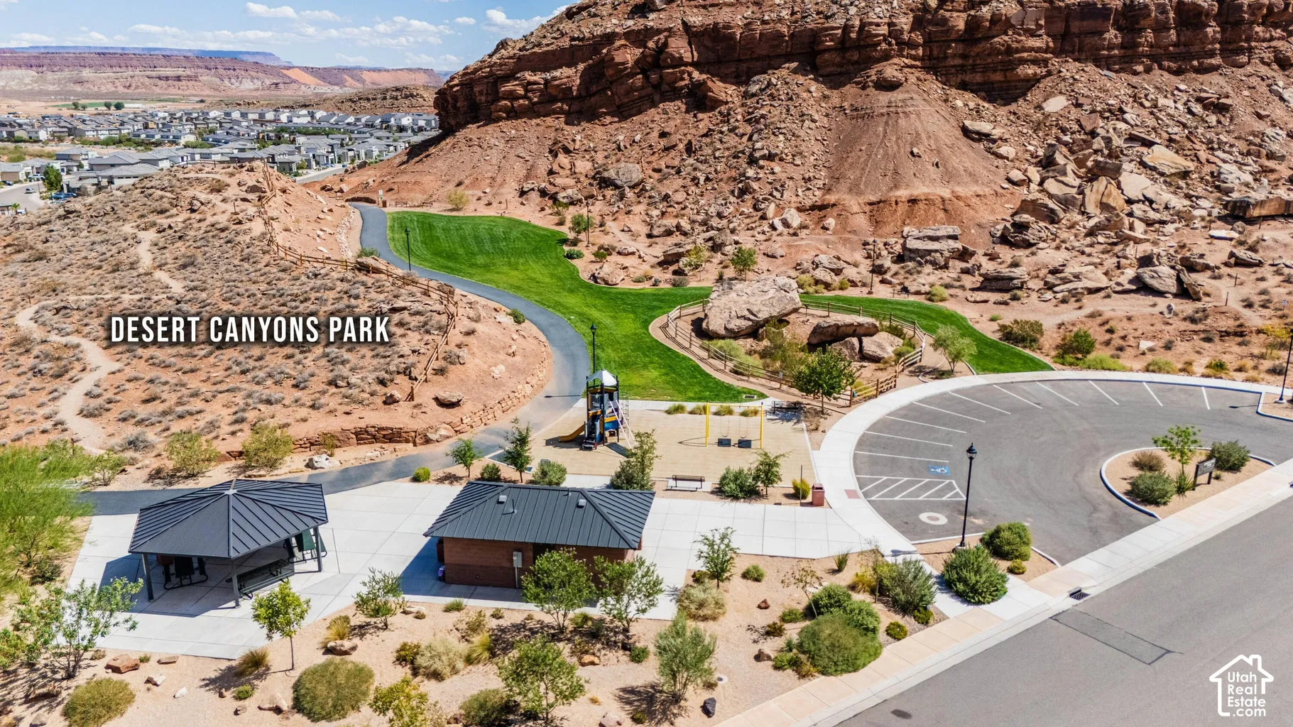 Desert Canyons Park featuring playground equipment, a paved walking path, and a shaded picnic area