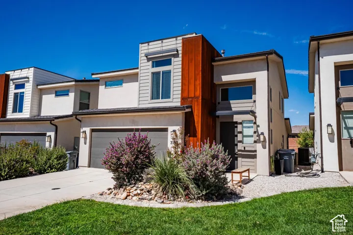 Contemporary exterior with a flat roofline, attached garage, and stucco siding