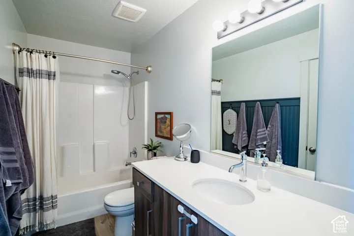 White vanity with a single integrated sink, chrome faucet, and wood-finish cabinetry