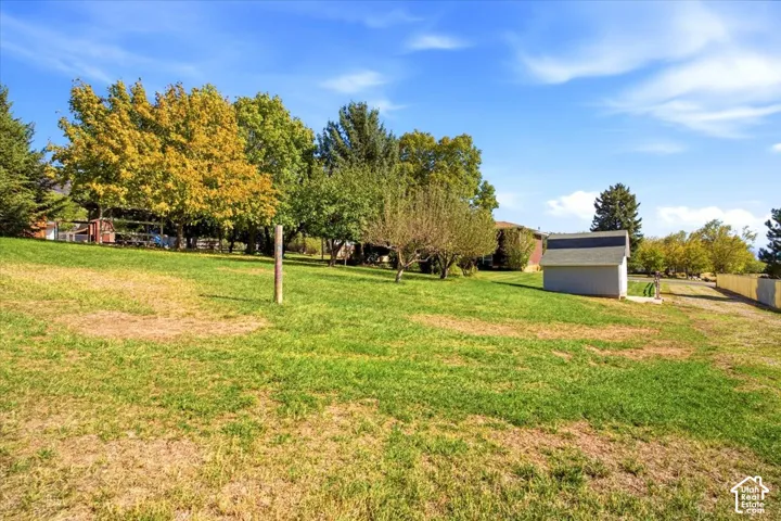 Expansive grounds featuring mature shade trees, manicured lawn, and detached garage structure
