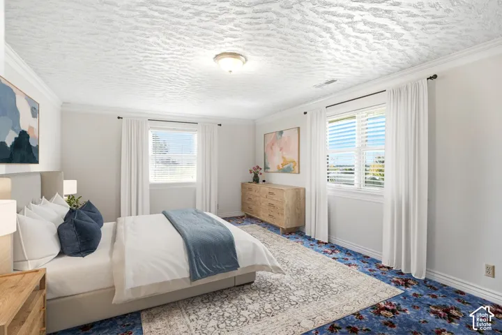 Recessed ceiling light fixture, crown molding, two windows with blinds, and contrasting carpet
