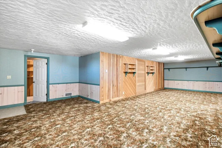 Spacious interior room with wood paneling and wainscoting