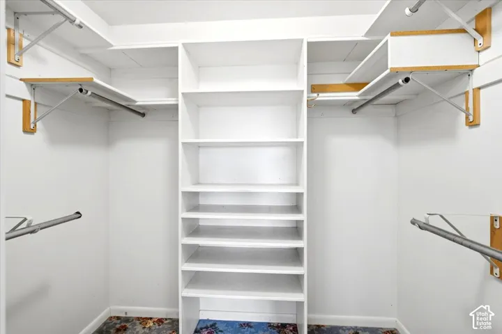 Built-in shelving unit, multiple hanging rods, and upper storage shelves