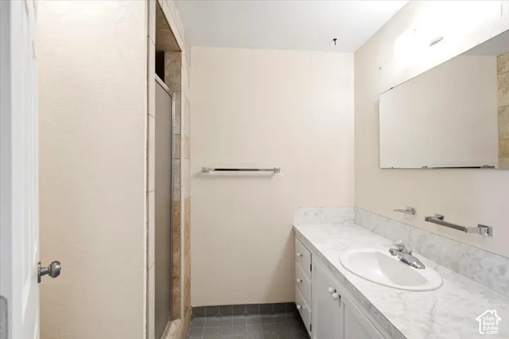 Vanity with integrated sink, white cabinetry, and a light-colored countertop