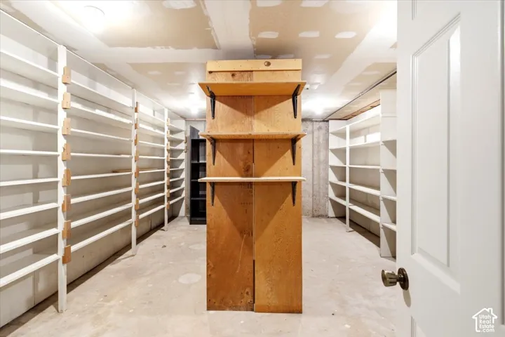 Extensive built-in shelving, concrete flooring, and a solid core door
