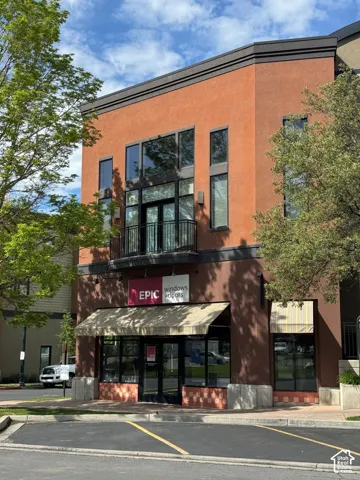 Multi-story commercial building featuring a stucco facade and prominent storefront with awnings