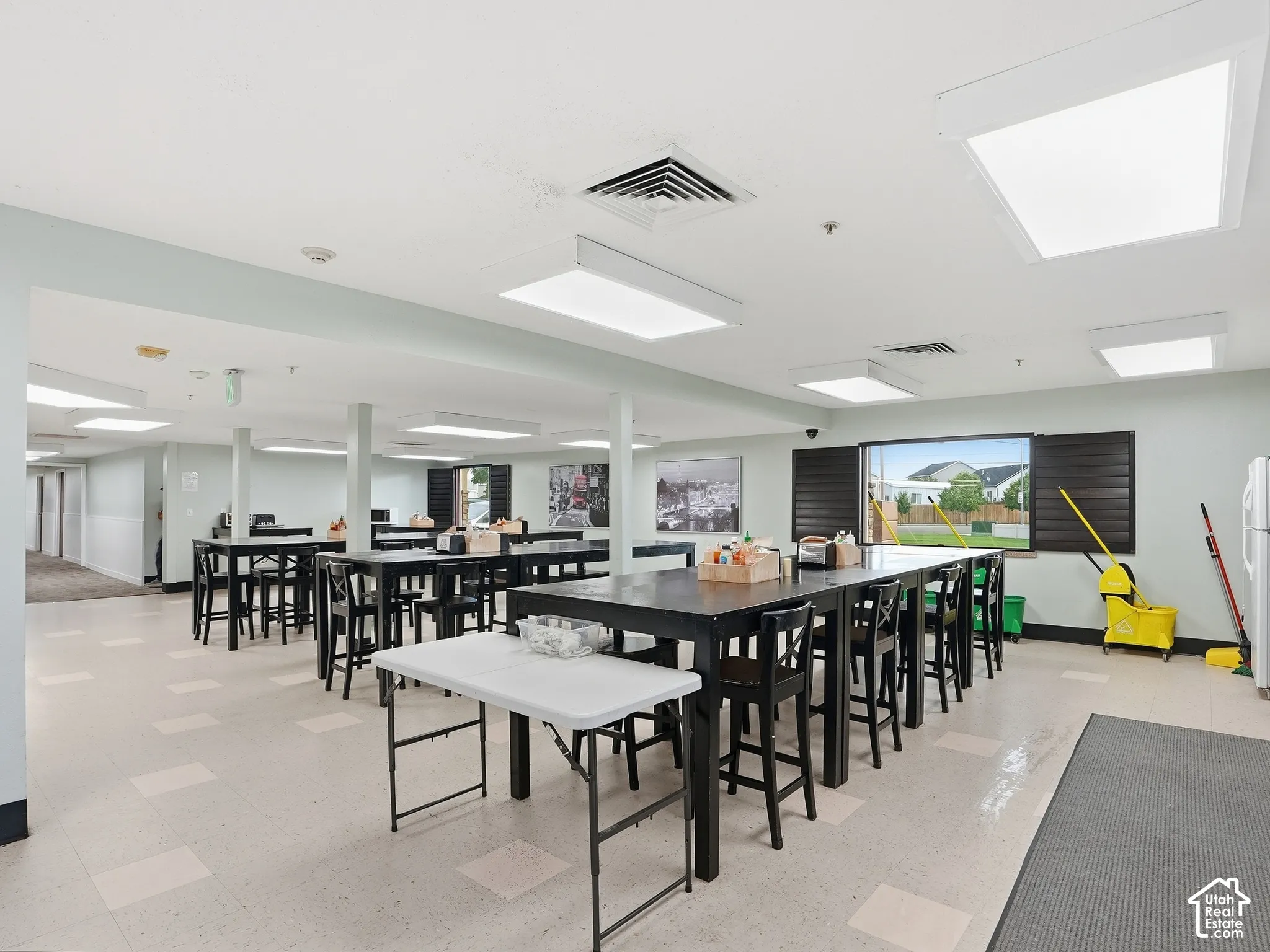 Spacious common area featuring large rectangular windows, recessed lighting, and durable flooring