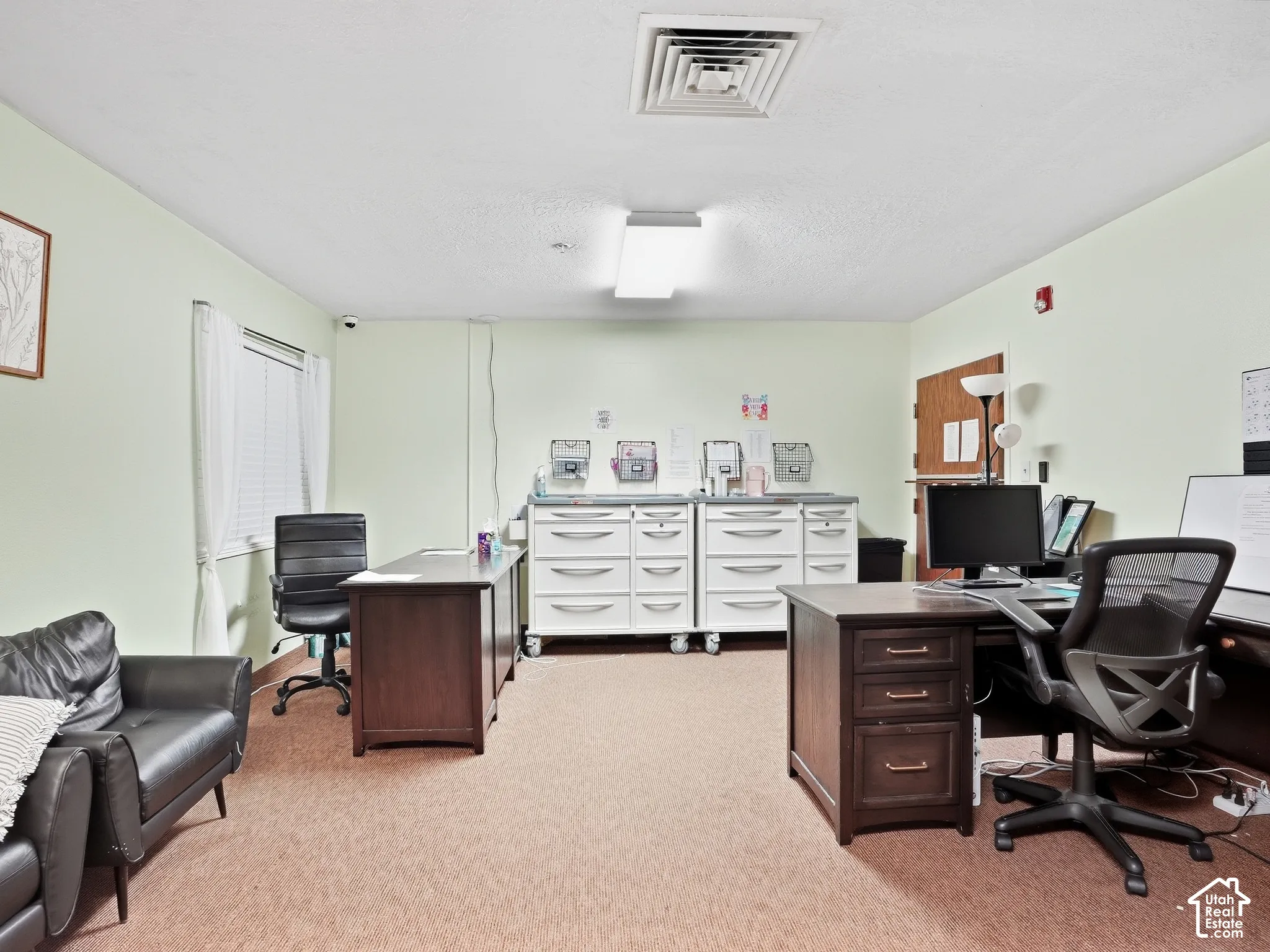 Recessed ceiling lighting, window with blinds, light-colored walls, and carpeted flooring