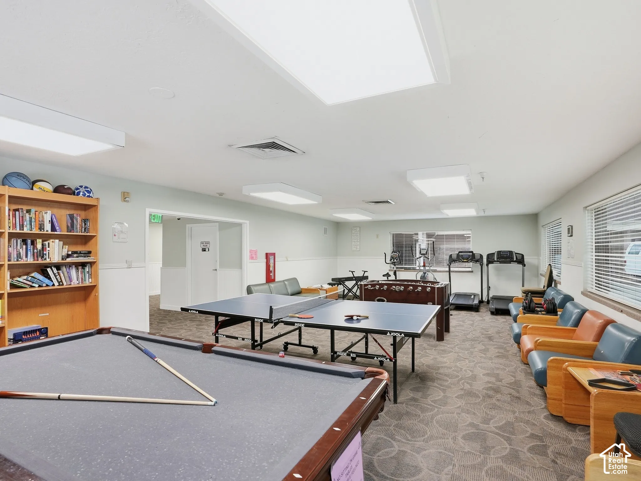 Recreational room featuring a billiard table, ping pong table, fitness equipment, and built-in shelving