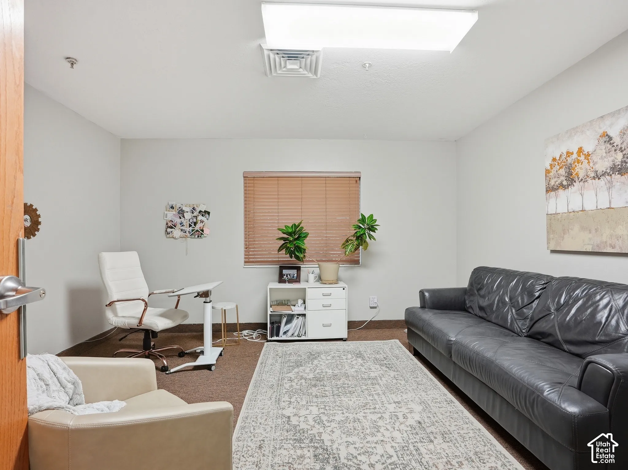 Recessed ceiling lighting, light neutral wall paint, window with horizontal blinds, wood-finish door, and carpet flooring