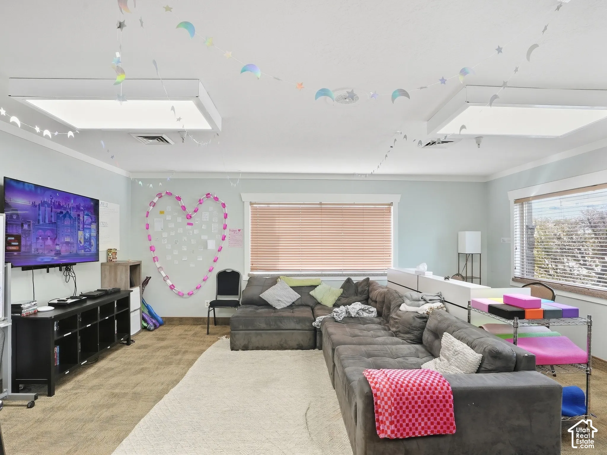 Recessed lighting fixtures, crown molding, and two large windows with blinds