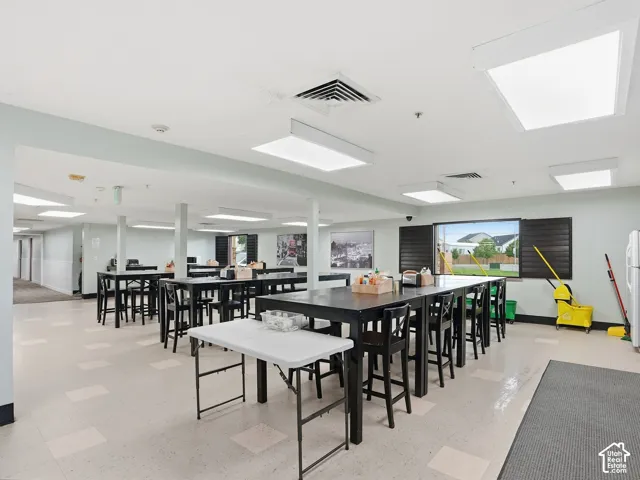 Spacious common area featuring large rectangular windows, recessed lighting, and durable flooring