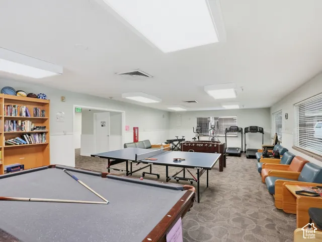Recreational room featuring a billiard table, ping pong table, fitness equipment, and built-in shelving