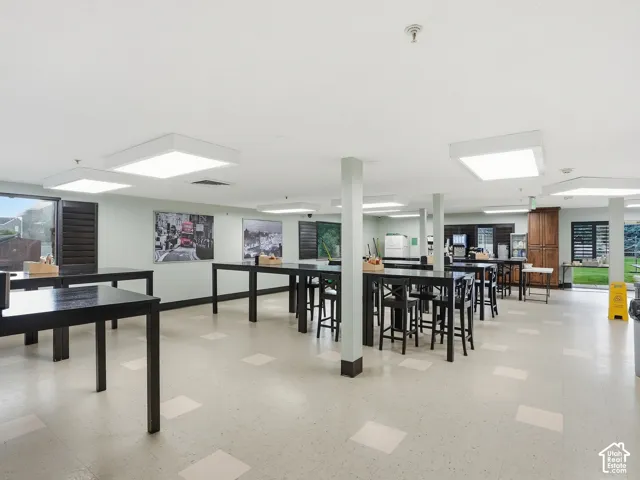 Spacious common area featuring patterned tile flooring, recessed lighting, and multiple large windows