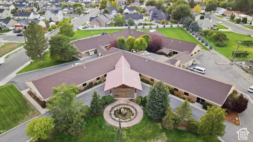 Expansive commercial property featuring a central courtyard with a fountain, multiple building wings, ample paved parking, and mature landscaping