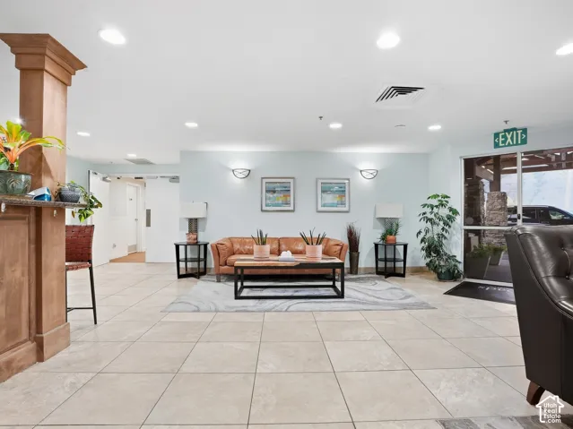 Recessed lighting illuminates the space, featuring tile flooring and light-toned walls
