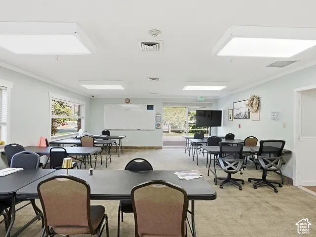 Carpeted common area featuring multiple windows, recessed lighting, and a whiteboard