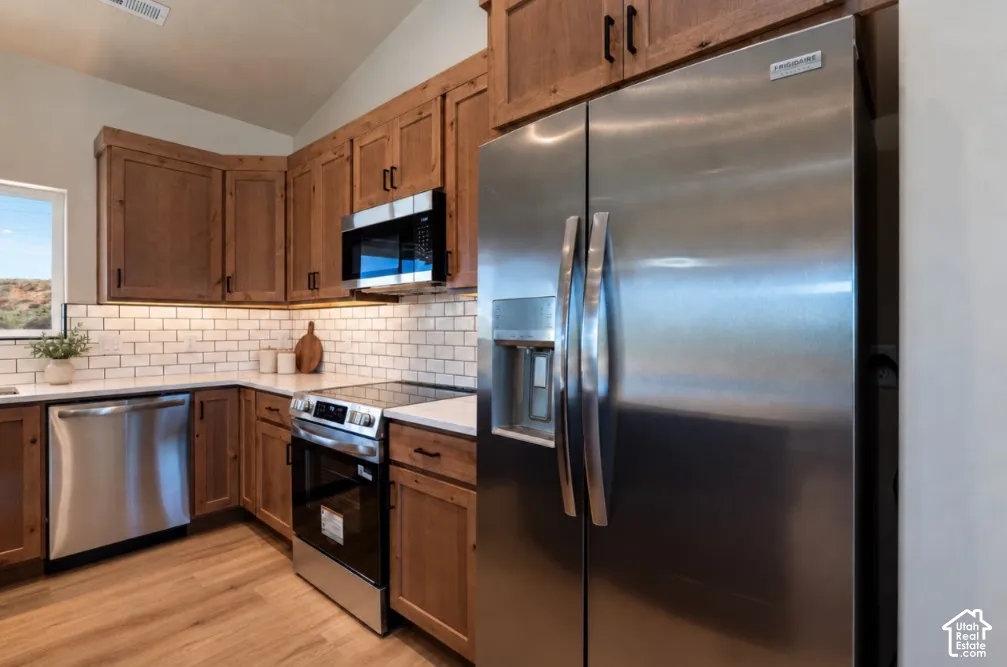 Wood-finish cabinetry paired with a white subway tile backsplash