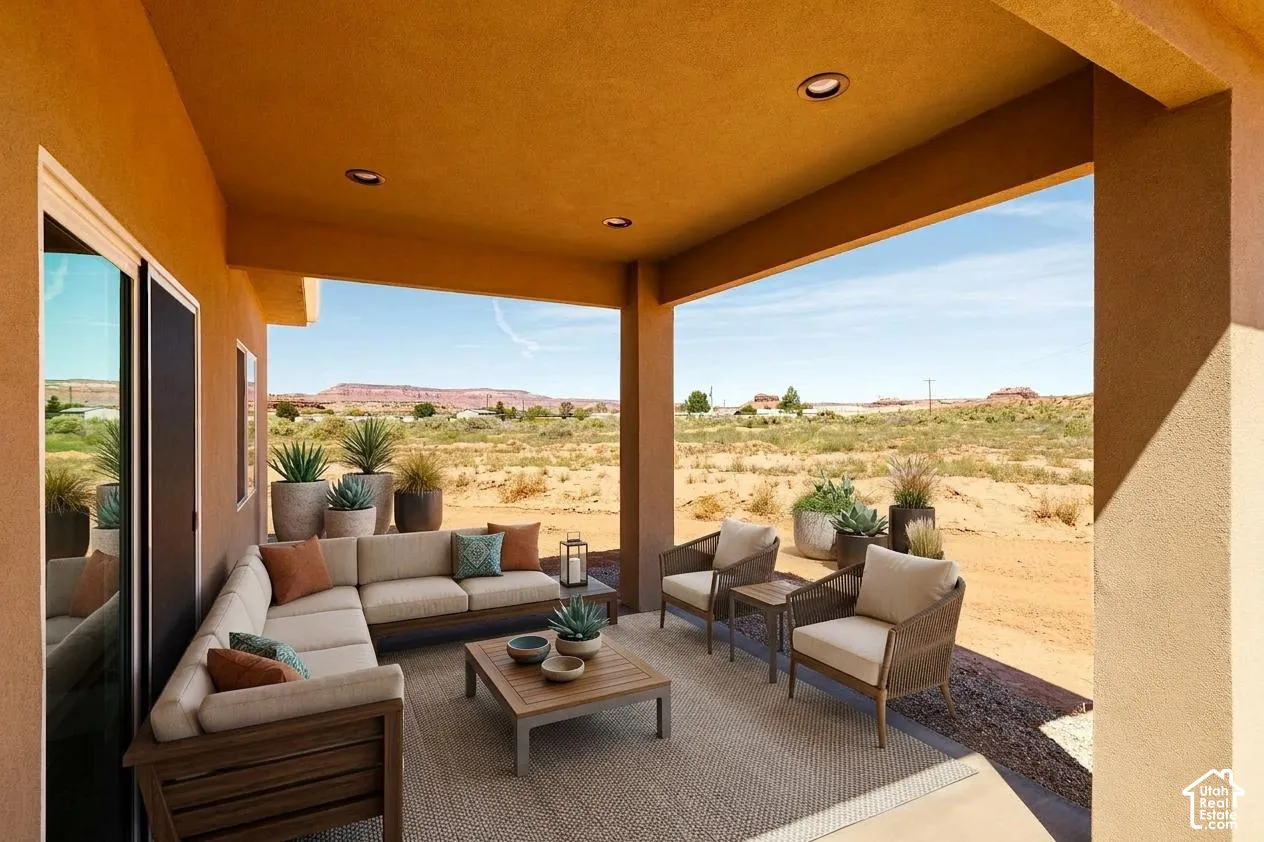 Covered patio with recessed lighting, stucco exterior, and desert landscaping
