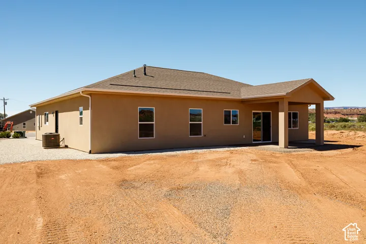 Tan stucco exterior with brown shingles