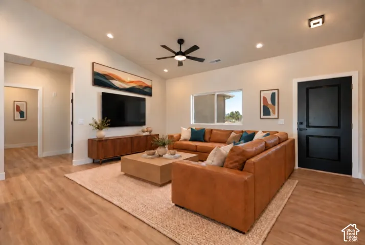Vaulted ceiling, wood-finish flooring, recessed lighting, ceiling fan, and black paneled door