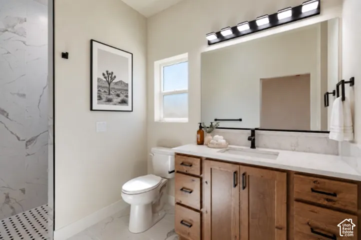 Spacious bathroom featuring a single window, a built-in wooden vanity with ample storage, a large mirror, and a walk-in shower with patterned floor tiles