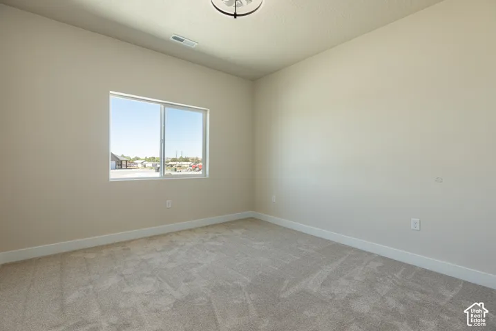 Carpeted flooring, neutral wall tones, and a single window