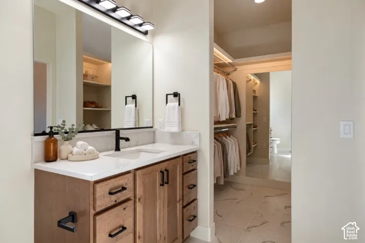 Wood-finish vanity with a white countertop and undermount sink