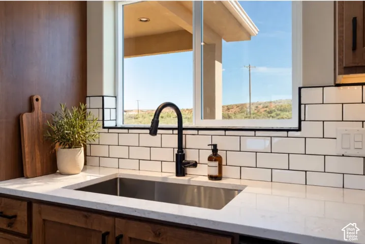 Stainless steel undermount sink with a matte black gooseneck faucet, set into a light-toned countertop