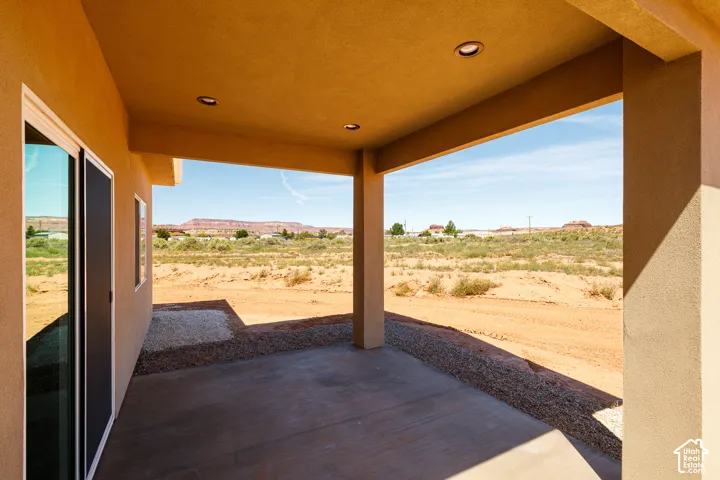 Covered concrete patio with recessed lighting and desert scenery