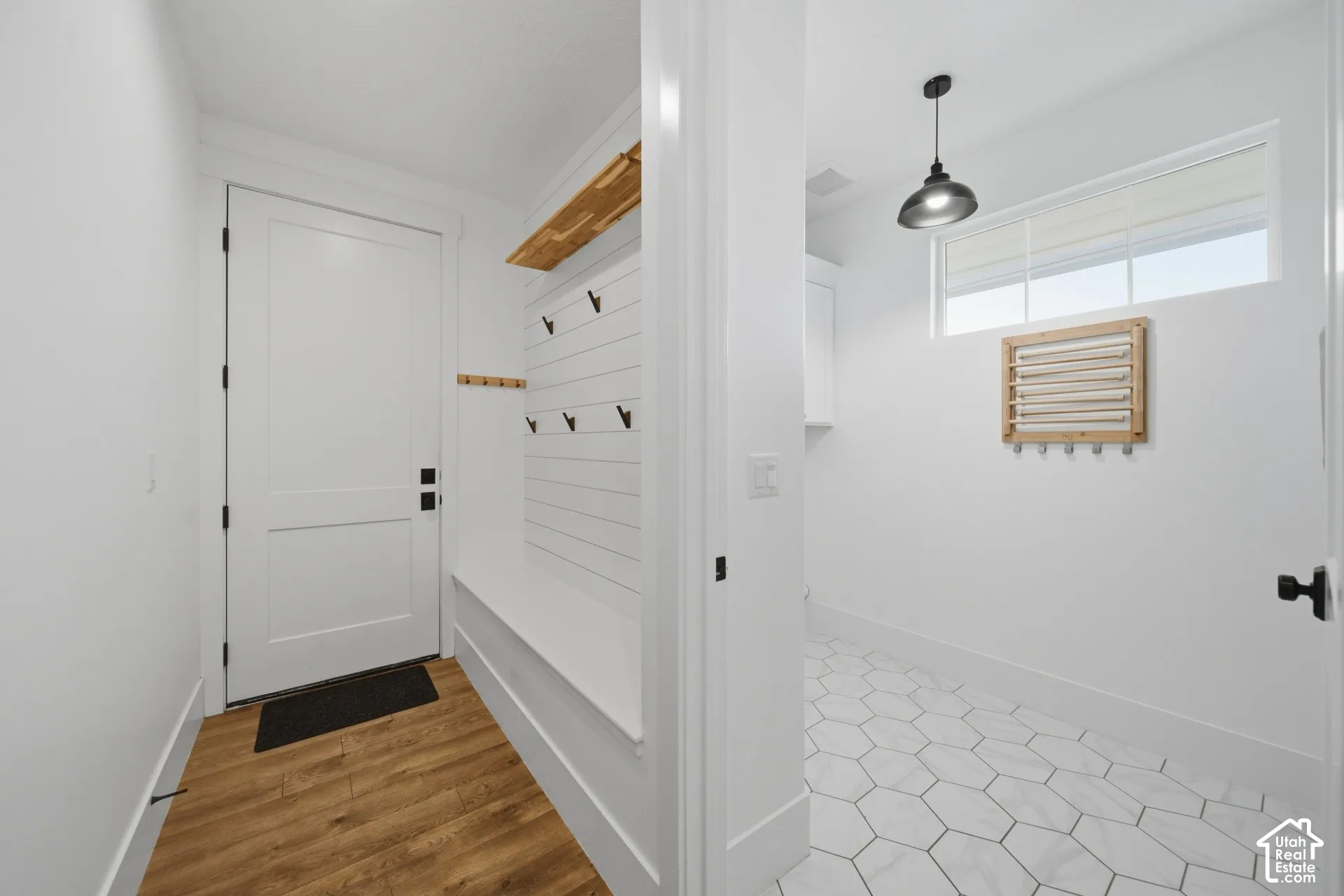 Mudroom with wood-finish flooring, built-in bench, and coat hooks
