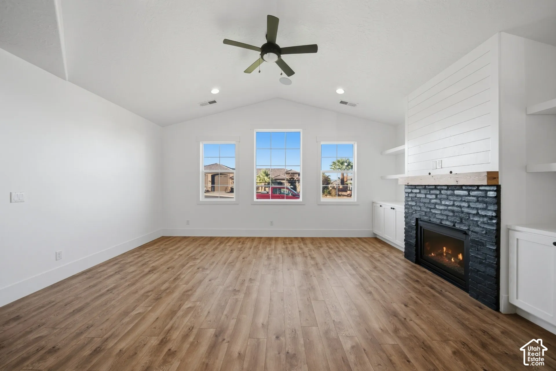 Vaulted ceiling with a ceiling fan, wood-finish flooring, and recessed lighting