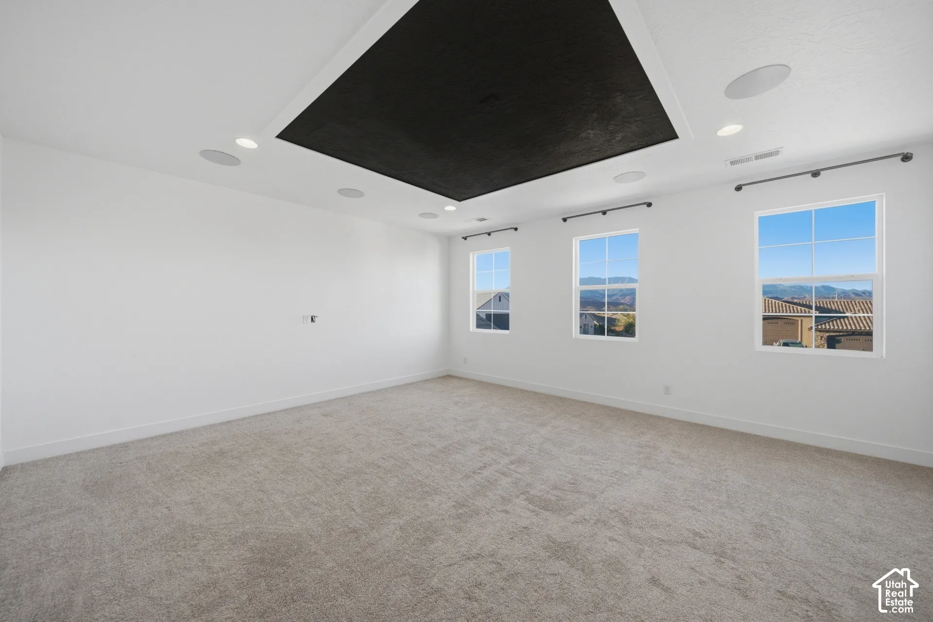 Recessed ceiling with integrated lighting, built-in ceiling speakers, three gridded windows, and wall-to-wall carpeting