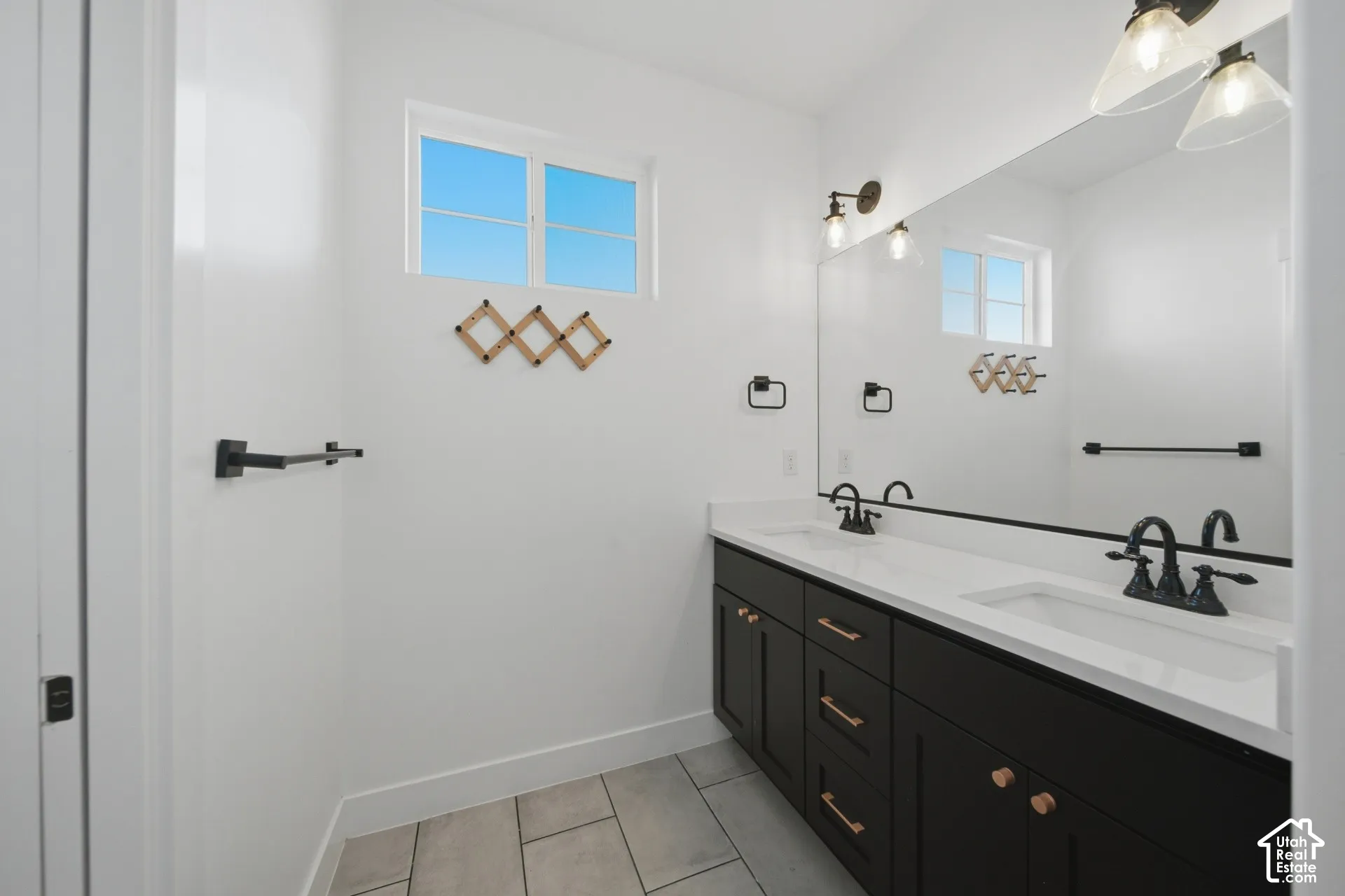 Dual vanity with dark cabinetry, white countertops, and matte black fixtures