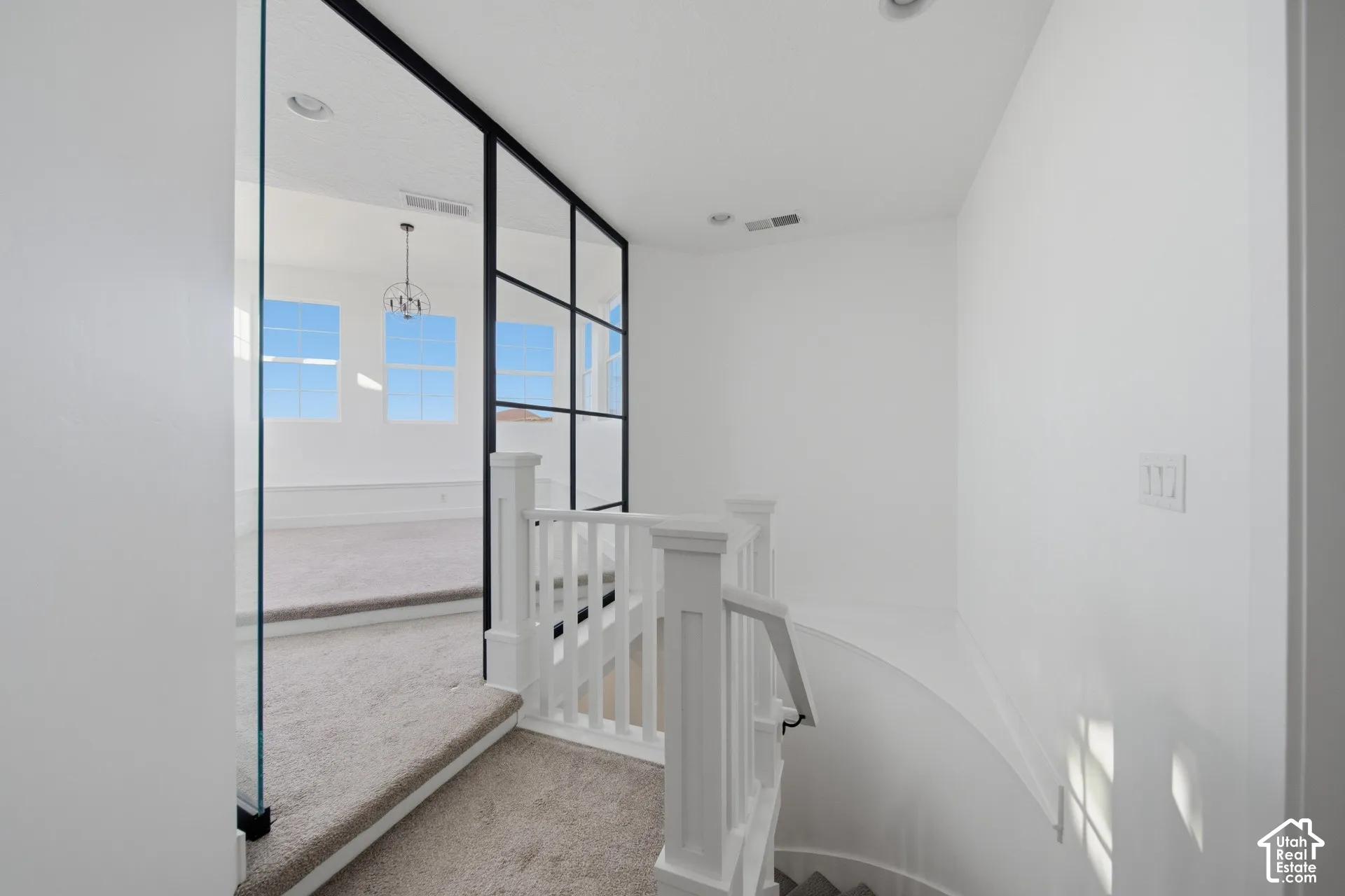 Contemporary glass and metal partition, white painted railing, and recessed ceiling lighting