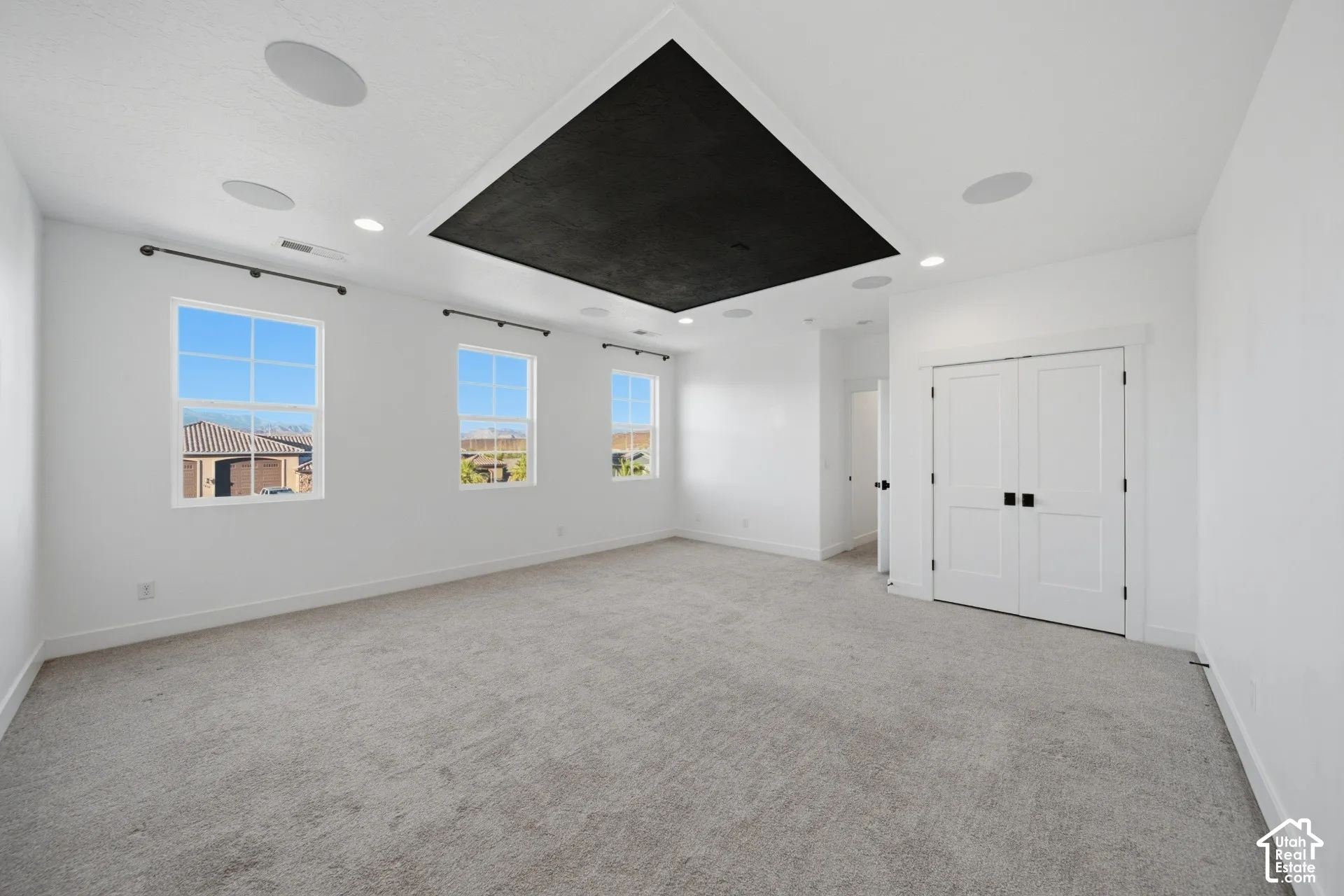 Recessed lighting, integrated ceiling speakers, and a central black ceiling accent